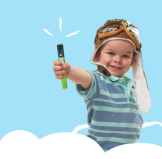 Four-year-old boy wearing an old fashioned, leather pilot&rsquo;s hat and goggles, smiling at camera and holding out a FlexPro&reg; pen.