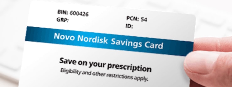 A closeup image of a hand holding a Novo Nordisk Savings Card. The card has a blue stripe, and includes the text, &lsquo;Save on your prescription.&rsquo;