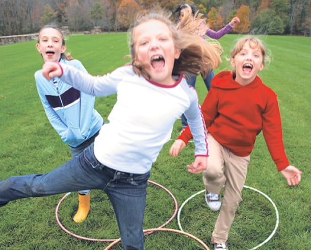 Photo of children playing with hula hoops.